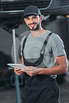 professional auto mechanic in overalls using