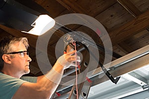 Professional automatic garage door opener repair service technician working closeup photo