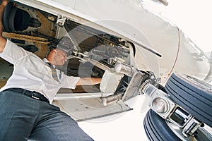 Professional aviator inspecting the aircraft undercarriage before the flight