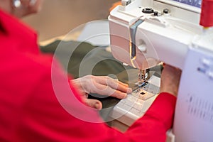 Hands making seam on fabric on sewing machine