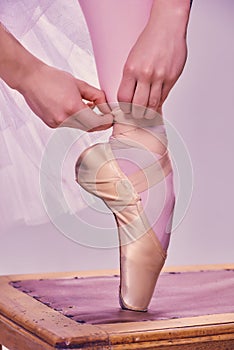 Professional ballerina putting on her ballet shoes.