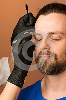 Correcting shape of eyebrows to male client