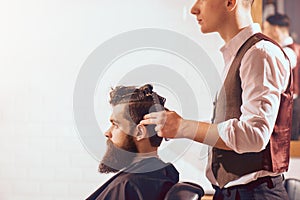 Professional barber styling hair of his client