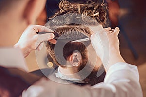 Professional barber styling hair of his client