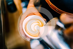 Professional barista, man making coffee latte art with espresso and foam milk