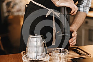 Professional barista preparing coffee by aeropress alternative method, brewing process. Hands on aeropress and glass cup, scales,