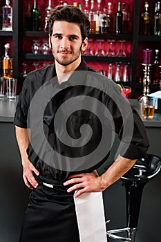 Professional barman in black standing bar photo