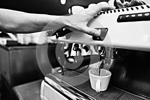 Professional barman at coffee machine making espresso in a cafe