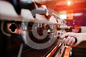 Professional barman at coffee machine with vapor making espresso