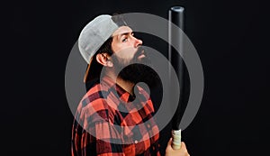 Professional baseball player. Bearded man in plaid shirt and cap with baseball bat. Sport equipment.