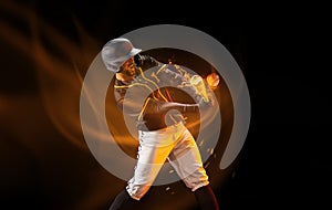 Professional baseball player in sports equipment training alone isolated on dark background with mixed light effect