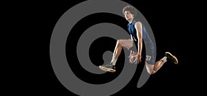 Professional basketball player in action and motion isolated on dark background. Concept of sport, competition
