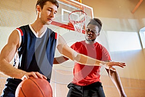 Professional basketball player dribbling near competitors basket