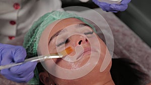 Professional beautician applying a face mask to a woman.