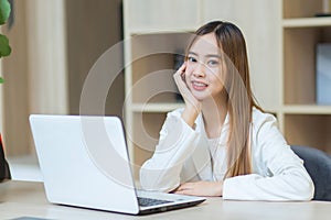 Professional beautiful young Asian business woman working in co-working space using laptop notebook, computer Business woman