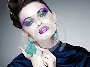 Professional blue make-up and hairstyle on beautiful woman face