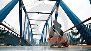 Professional break dancer perform street dance footstep at bridge. Sprightly.