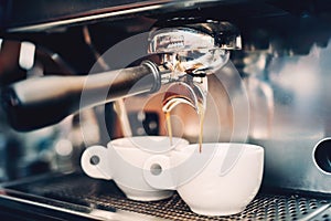 Professional brewing - coffee details. Espresso coffee pouring from espresso machine. Barista details in cafe