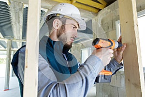 professional builder drilling hole in wall with perforator