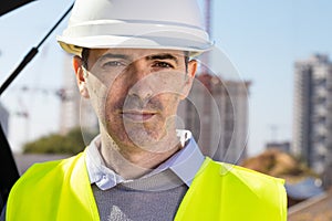Professional builder standing in front of the construction site