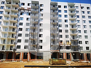 Professional builders carry out construction work on painting the facade with white paint. Construction of apartments in