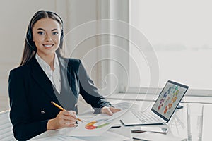 Professional business lady in headset preparing for online presentation