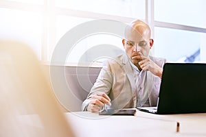 Professional business man working on his portable tablet and computer