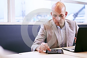 Professional business man working on his portable tablet and computer