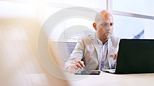 Professional business man working on his portable tablet and computer