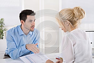 Professional business meeting: customer and advicer analyzing financial situation.