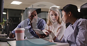 Professional business people discussing over a digital tablet in modern office in slow motion