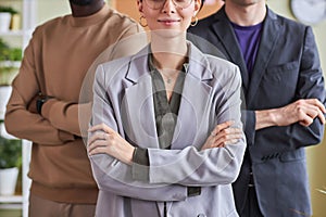 Professional business team in office posing confidently with arms crossed