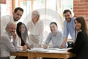 Professional business team young and old people posing at table photo