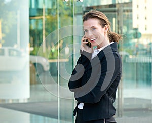 Professional business woman smiling with mobile phone outside
