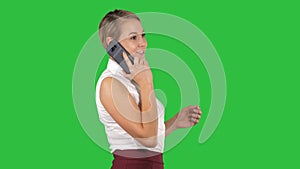 Professional business woman smiling with mobile phone talking on a green screen, chroma key.