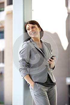 Professional business woman standing with mobile phone