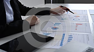 Professional business woman working with statistics document at white office desk