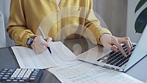 Professional business woman in yellow blouse is working on financial reports. Close-up of a woman's hands as she