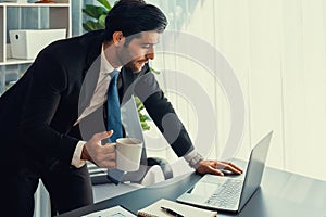 Professional businessman at modern office desk with confused expression. fervent