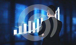 Businessman Analyzing Growth Trends on Digital Screen with Graphs and Charts in Modern Office Environment Impute