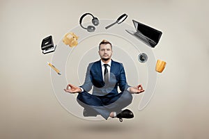 A professional businessman in a suit levitates with many objects. Works in different directions. Multitasking, efficient business