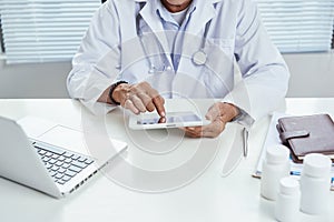 Professional businessman using modern digital tablet at his office, doctor working on a tablet pc