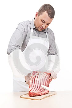 Professional butcher cutting ribs on board.