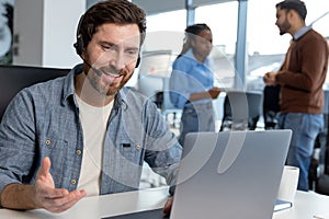 Professional call center operator man in headset working on laptop