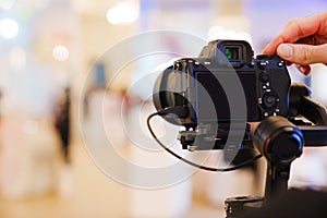 A professional camera on the blurred background of a banquet hall.