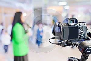 A professional camera on the blurred background of a banquet hall.