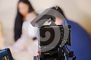 A professional camera on the blurred background of a banquet hall.