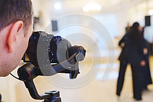 A professional camera on the blurred background of a banquet hall.