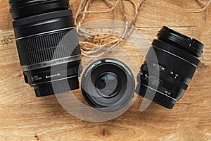 Professional camera lenses on the rustic wooden background. Flat lay. Mockup for photo or videomaker advertisement