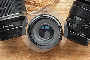Professional camera lenses on the rustic wooden background. Flat lay. Mockup for photo or videomaker advertisement
